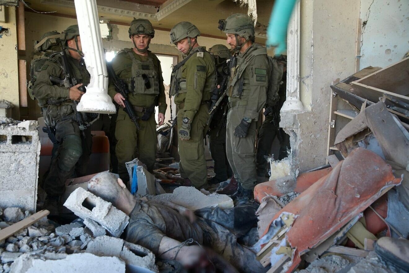 IDF officers stand over the body of Yahya Sinwar, Gaza, Oct. 17, 2024. (Credit: IDF/JNS)