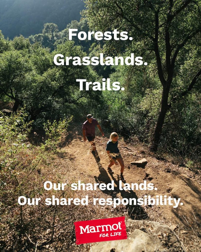 Two hikers on forest trail with environmental responsibility message