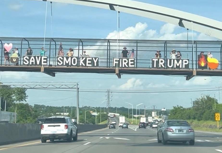 Highway overpass with Save Smokey Fire Trump protest banner